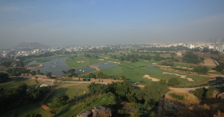 Aerial view of Hyderabad Golf Club showing the course layout with the historic Golconda Fort in the background.